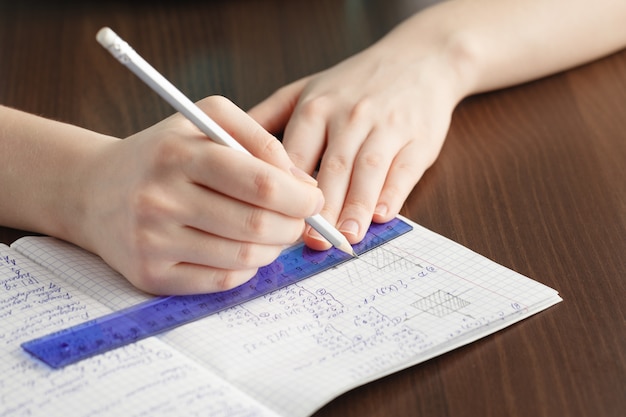 Fille écrit Dans Un Cahier De Formules Mathématiques