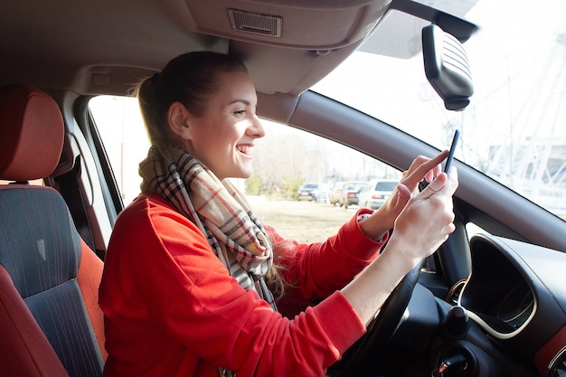 La fille écrit un message dans la voiture