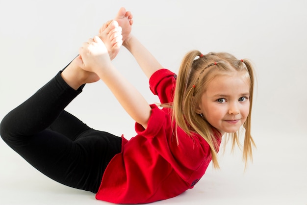 Fille effectue des exercices de gymnastique, un enfant actif, est engagé avec plaisir et sourires