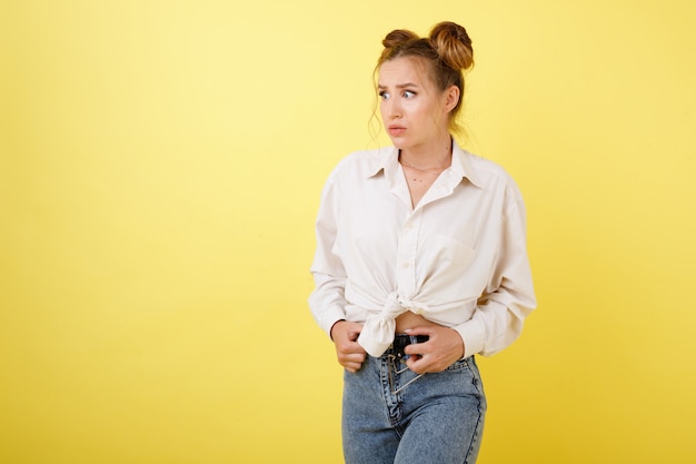 Fille effrayée et perplexe sur un espace jaune