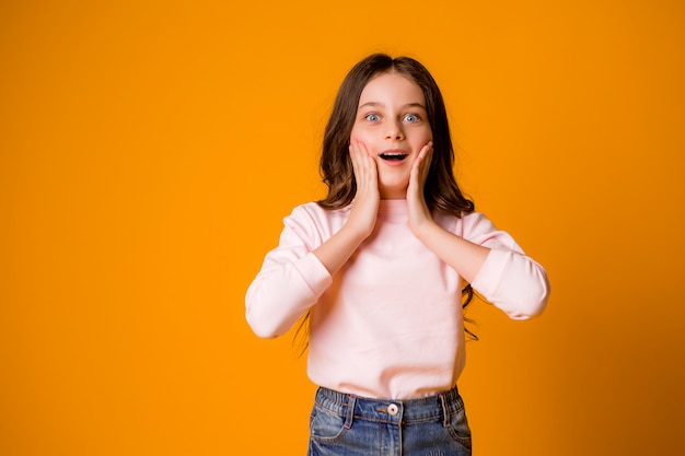 Fille effrayée ou surprise avec les mains sur son visage