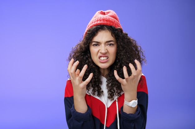 Fille élégante énervée et agacée serrant les mains de colère grimaçant serrant les dents de contrariété et ...