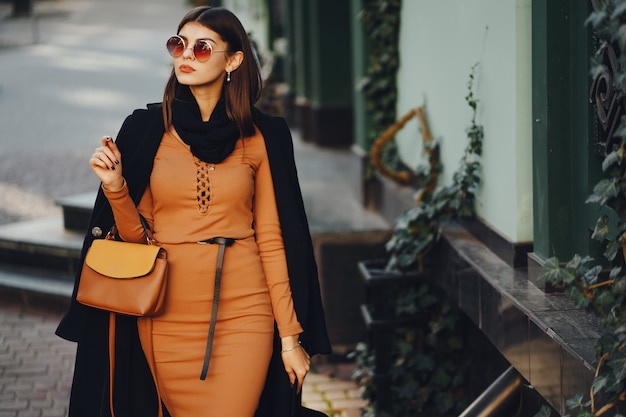 Photo fille élégante, marchant dans la ville sur une chaude journée d'automne ensoleillée