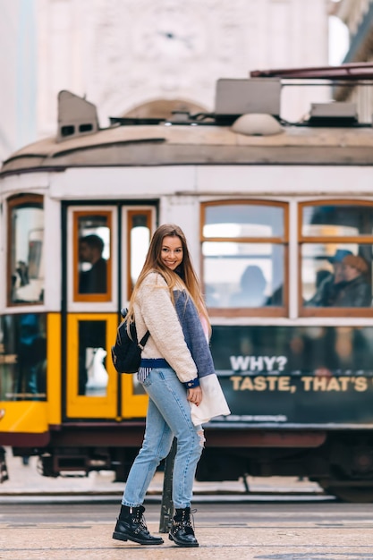 Photo une fille élégante avec un sac à dos regarde la caméra et sourit.