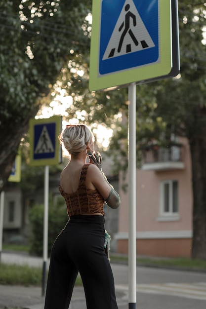 Une fille élégante traverse le panneau de signalisation de la route