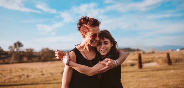 Fille embrassant mère dehors