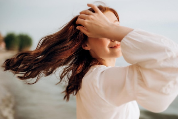 Fille enceinte aux cheveux bruns au bord de la mer