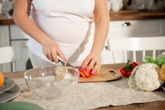 Une fille enceinte cuisine dans la cuisine à la maison Mise au point sélective