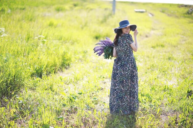 Fille enceinte dans un champ de lupins