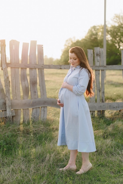 Fille enceinte en été à l'extérieur au soleil couchant