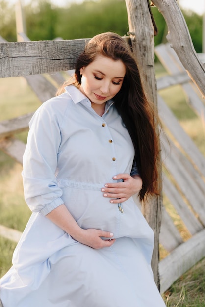 Photo fille enceinte en été à l'extérieur au soleil couchant