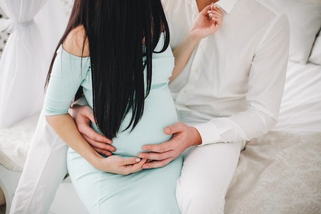 Fille enceinte avec un gars et des vêtements blancs