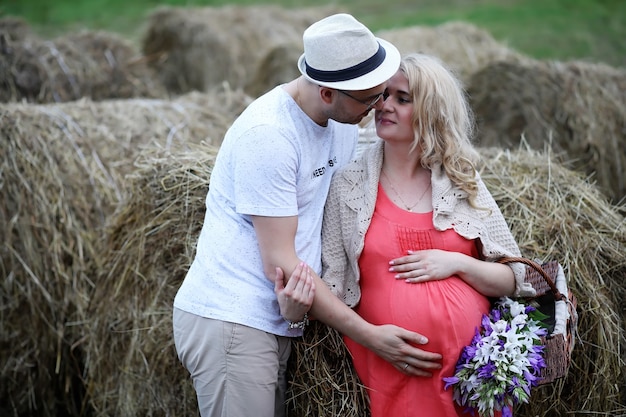 Fille enceinte avec gros ventre et jeune homme dans le parc