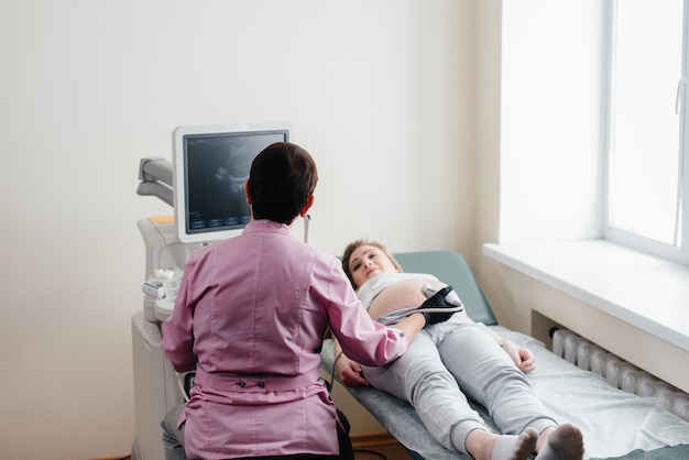Une fille enceinte reçoit une échographie de son abdomen à la clinique. Examen médical.