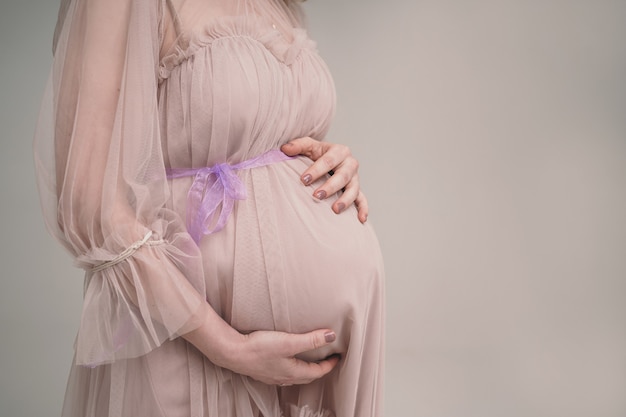 Une fille enceinte tient son ventre. Une jeune mère attend la naissance d'un enfant.