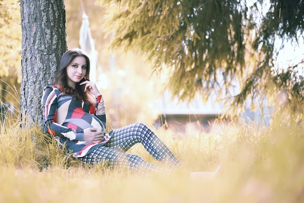 Fille enceinte vêtue d'une robe dans la nature lors d'une promenade