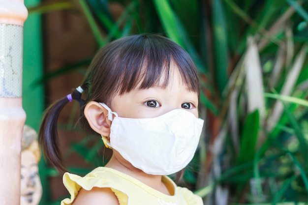 Fille enfant asiatique souriant et portant un masque en tissu,