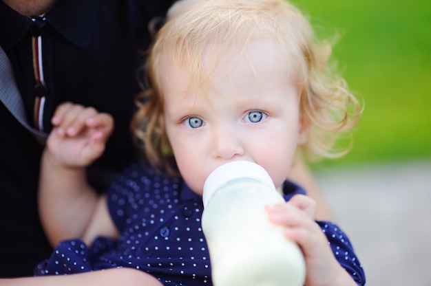 Photo fille enfant en bas âge, boire du lait de bouteille