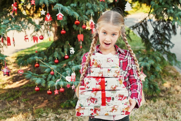 fille enfant avec des cadeaux près d'un arbre de Noël,