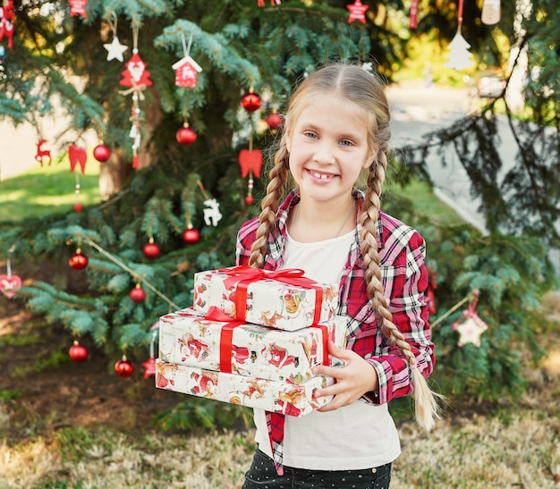 fille enfant avec des cadeaux près d'un arbre de Noël,