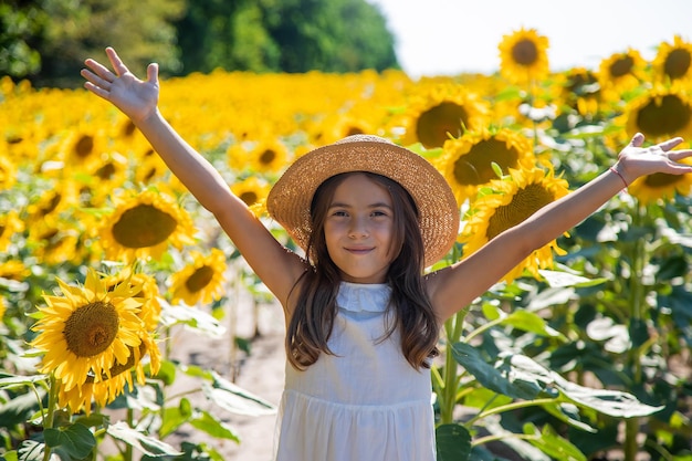 Fille enfant dans un champ de tournesols. Mise au point sélective. Enfant.