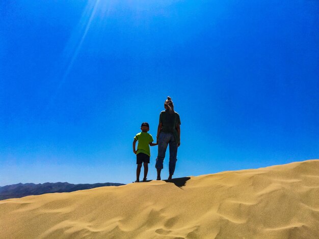 Une fille avec un enfant sur les dunes de sable de Sarykum un monument naturel Daghestan Russie