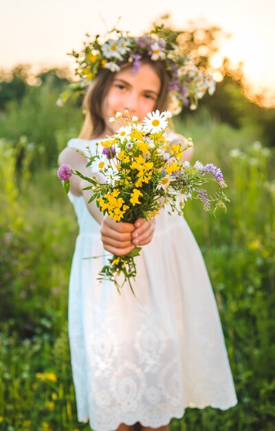 Fille enfant avec des fleurs sauvages en été