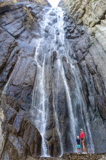 Une fille avec un enfant sur le fond de la cascade AbaiSu KabardinoBalkaria juin 2021