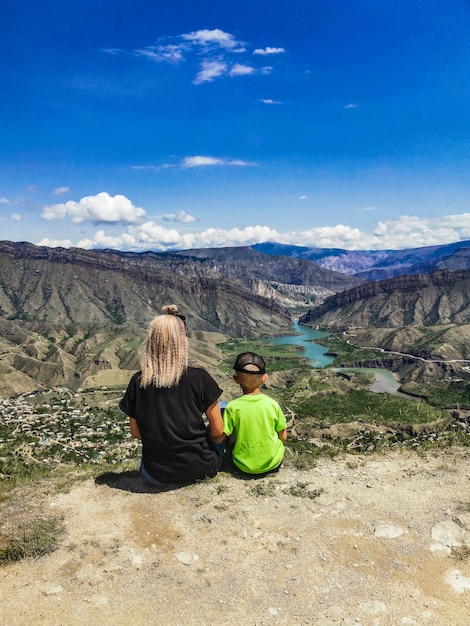 Une fille avec un enfant sur fond de montagnes près de la forteresse de Gunib Russie Daghestan juin 2021