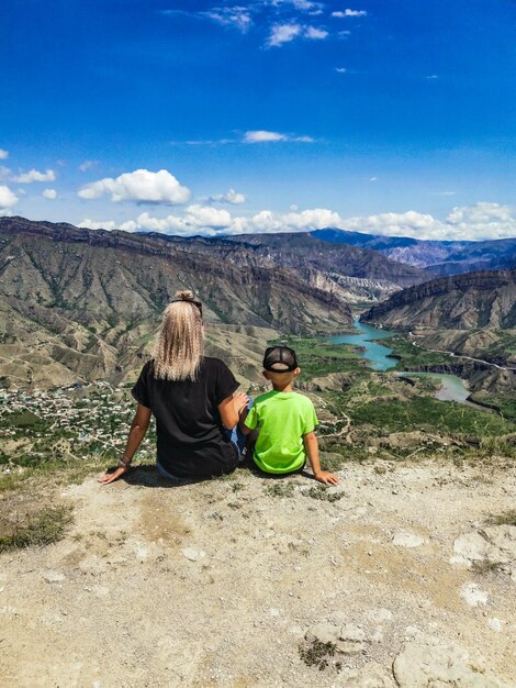 Une fille avec un enfant sur fond de montagnes près de la forteresse de Gunib Russie Daghestan juin 2021