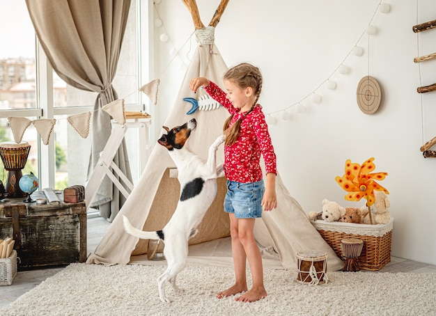 Fille enfant formation chien fox terrier dans la lumière de la chambre des enfants