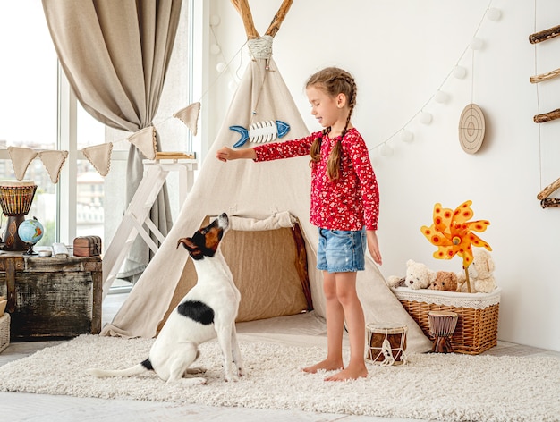 Fille enfant formation chien fox terrier dans la lumière de la chambre des enfants