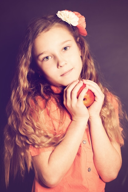 Fille d'enfant avec le fruit de pomme rouge