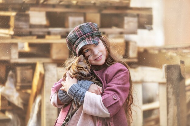 Fille Enfant à La Mode Belle Et Heureuse Avec Un Mignon Petit Chaton Bengal Ensemble Dans La Rue