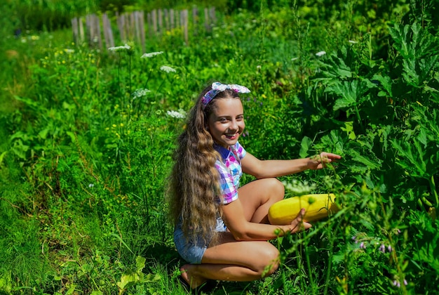 Fille enfant petit agriculteur fier de récolter la courge jaune