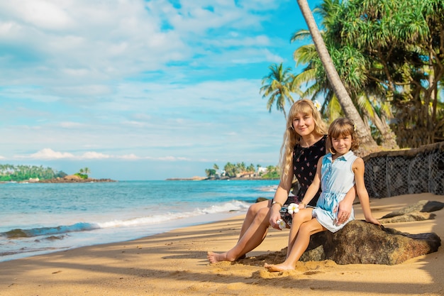 Fille enfant sur la plage avec sa mère.