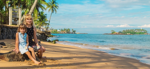 Fille enfant sur la plage avec sa mère