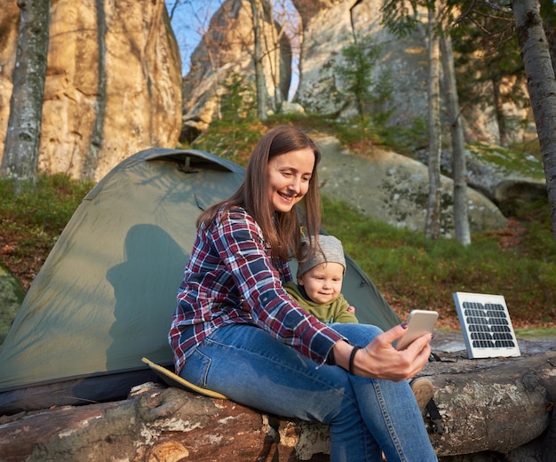 La fille et l'enfant prennent un selfie au téléphone portable au fond du te