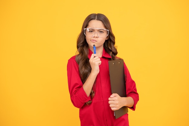 Fille enfant réfléchie dans les lunettes tenir la concentration du dossier papier