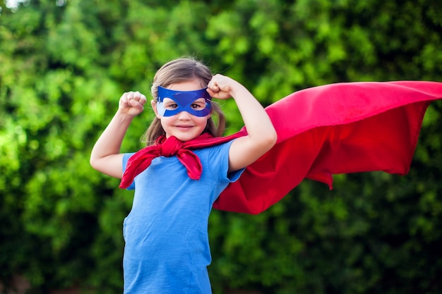 Fille enfant super-héros contre extérieur vert