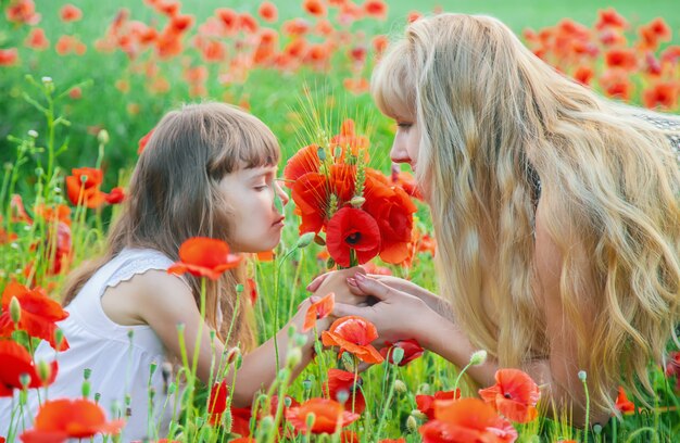 Fille d&#39;enfants dans un champ avec des coquelicots. mise au point sélective.