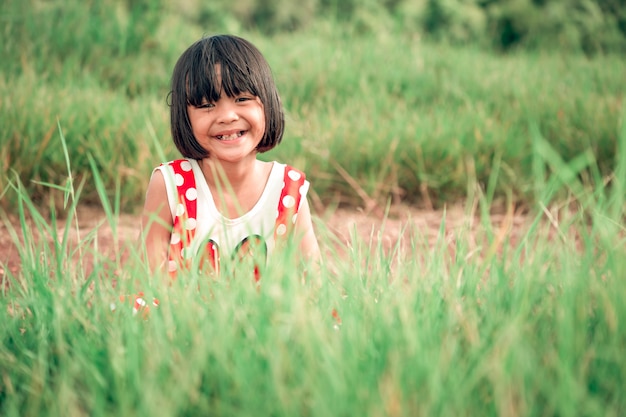 Fille enfants jouant et sourire sur la nature des pâturages des prairies