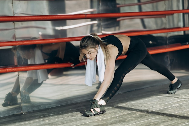 Fille entraînement matinal d'entraînement dans le gymnase. Jeune femme faisant des exercices de gym dans la salle de gym. Mode de vie sain et sportif