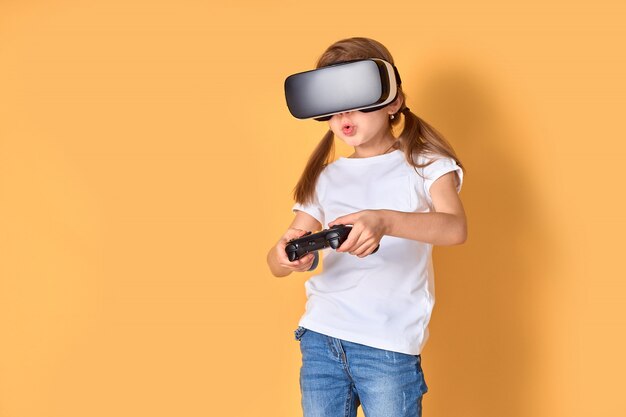 Fille éprouvant casque VR vs joystick. Des émotions surprises sur son visage. Enfant utilisant un gadget de jeu pour la réalité virtuelle.