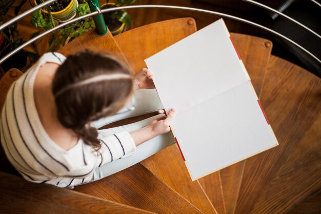 La fille sur les escaliers lisant un livre