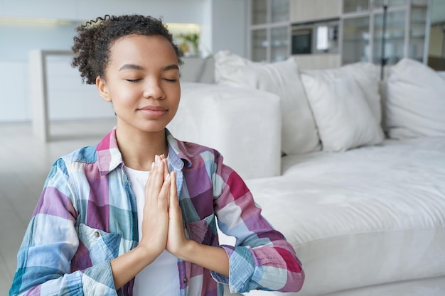 Une fille espagnole est assise en position du lotus, les yeux fermés Soulagement du stress et santé mentale