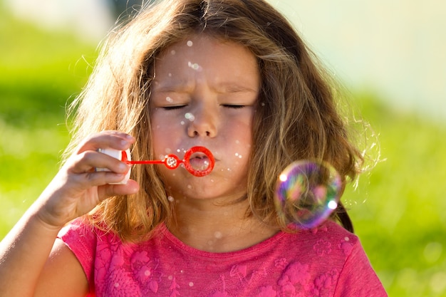 Fille essayant de souffler des bulles