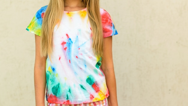 Fille essayant un t-shirt peint dans le style de colorant tie.