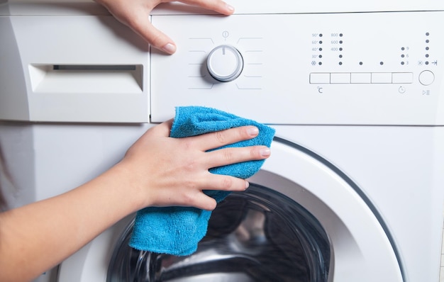 Fille essuyant la machine à laver en tissu