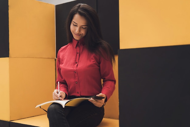 La fille est assise dans un mobilier moderne. Elle est dans le magasin.